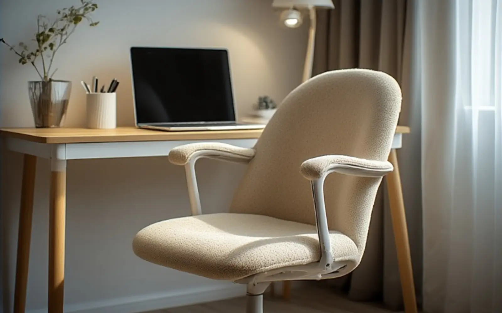 Cream boucle ergonomic desk chair paired with a light desk in a feminine small-apartment workspace.